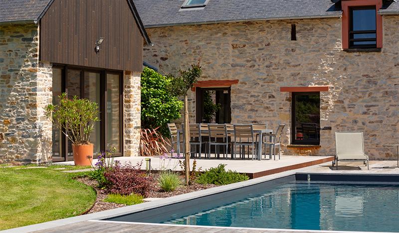 vue d’une piscine en béton avec une maison en pierre