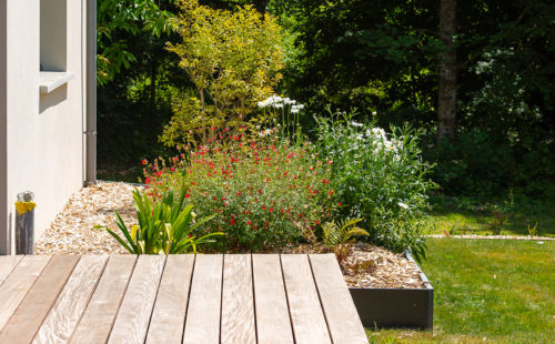 une terrasse en bois dans un jardin