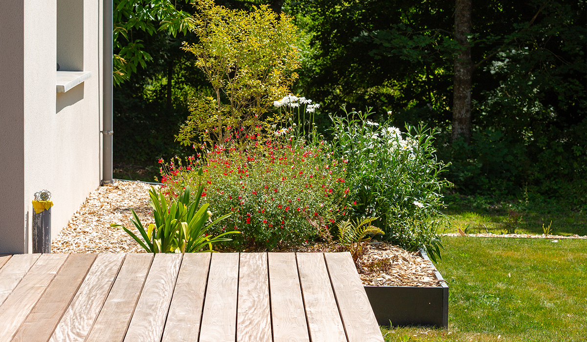 une terrasse en bois dans un jardin